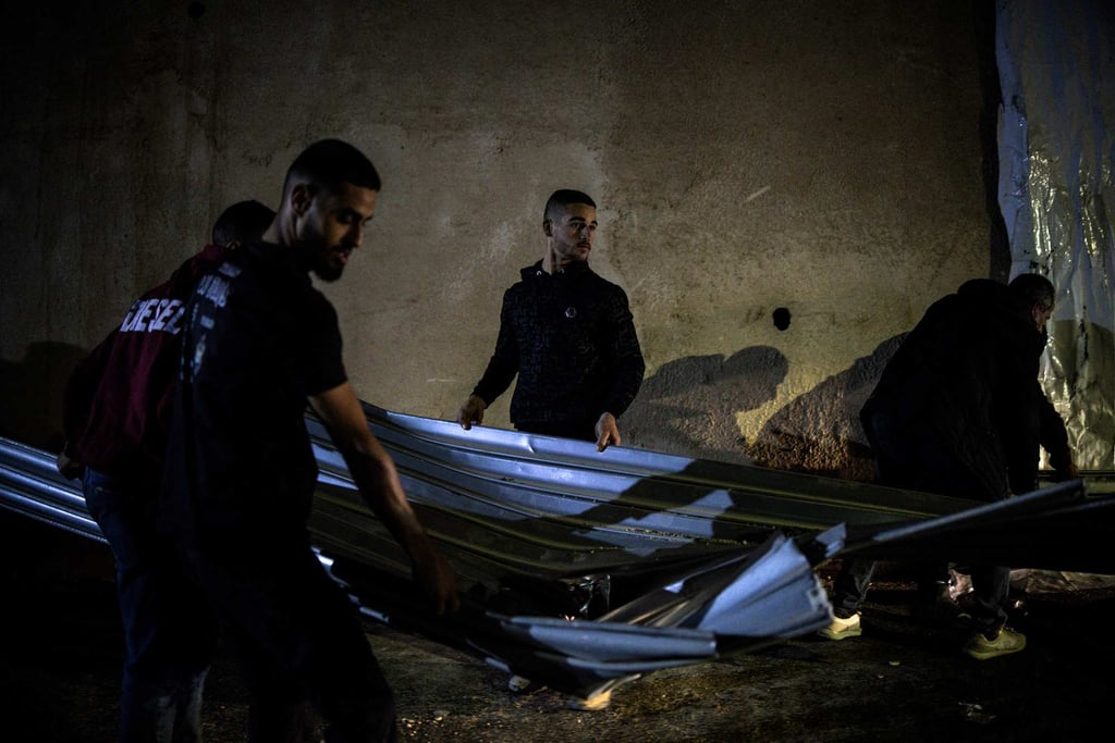 People help clean up at the site of a reported shooting that left two Palestinians dead during an Israeli military operation in the occupied West Bank city of Jenin on Thursday. Photo: AFP