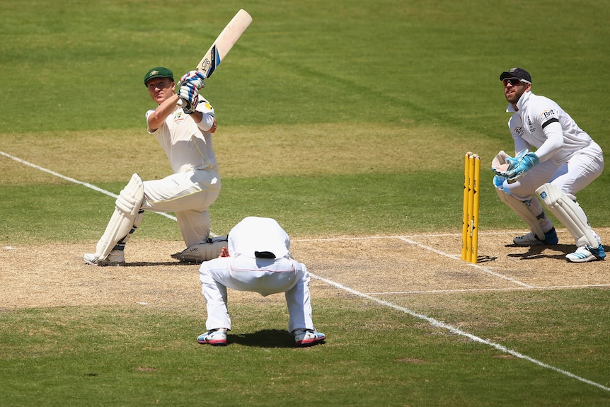 An Australian Test batsman sweeps for six, as an England close fielder flinches as the ball goes over his head.