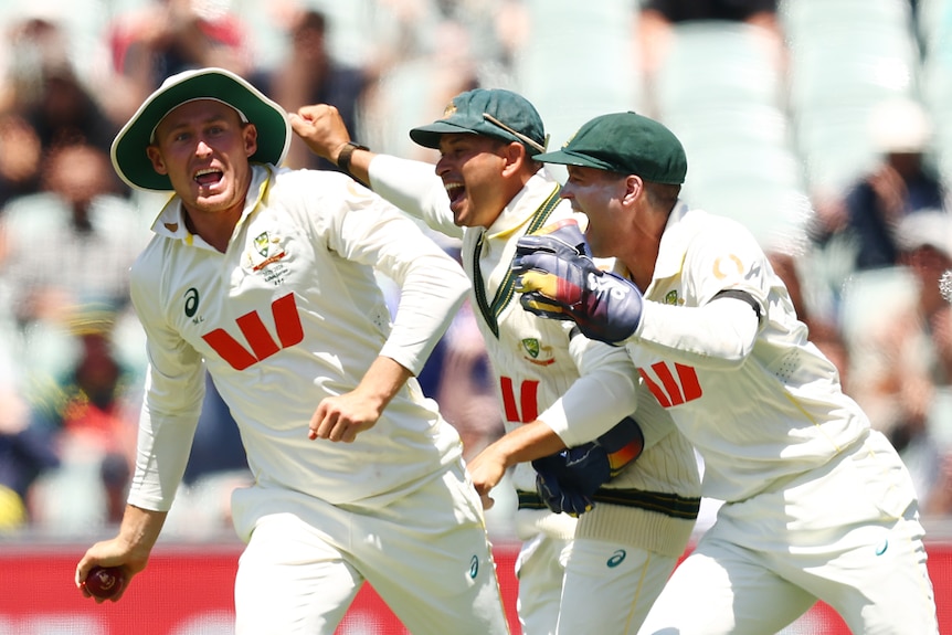 Marnus Labuschagne, Usman Khawaja and Alex Carey cheer on the field to celebrate a victory.