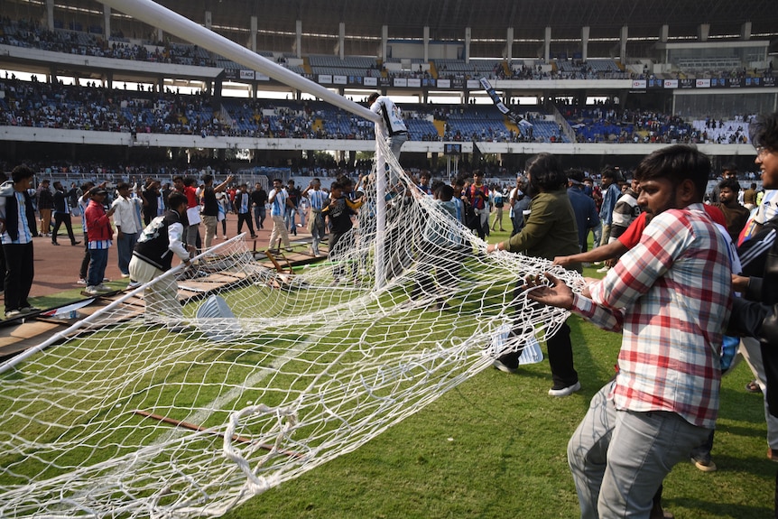 Fans rip a net off a goal.