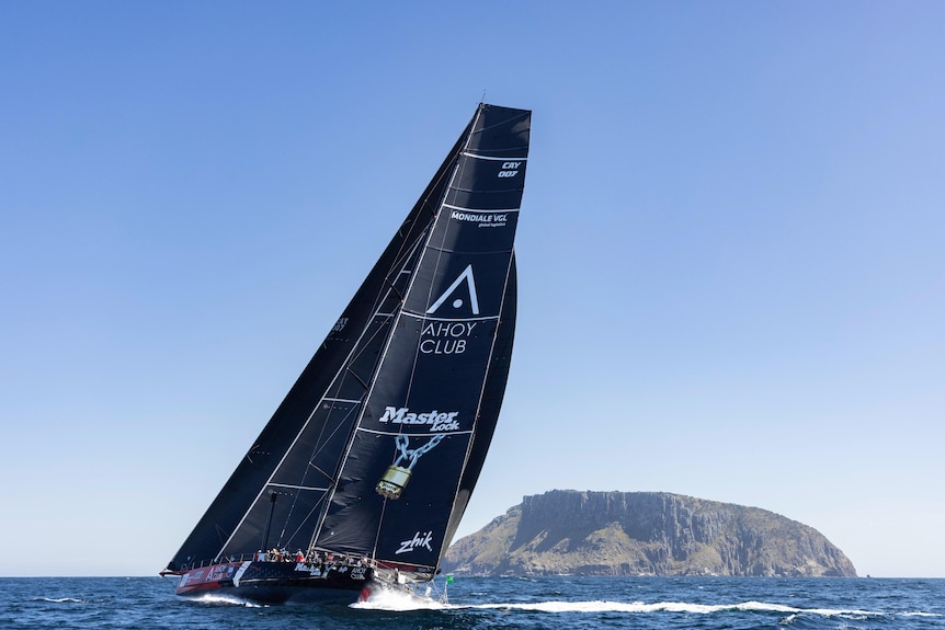 A yacht with black sails on a sunny day
