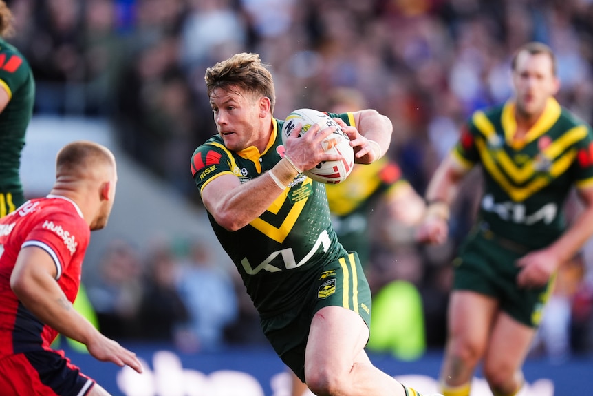 A man runs the ball during a rugby league match