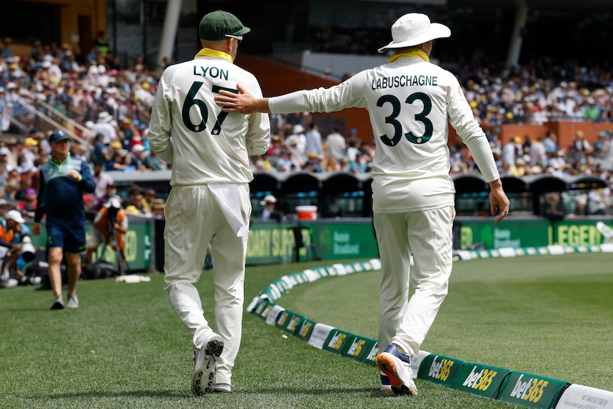 Marnus Labuschagne pats Australia teammate Nathan Lyon on the back as he leaves the field during an Ashes Test.