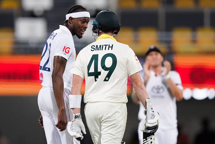 Two cricket players in white share words