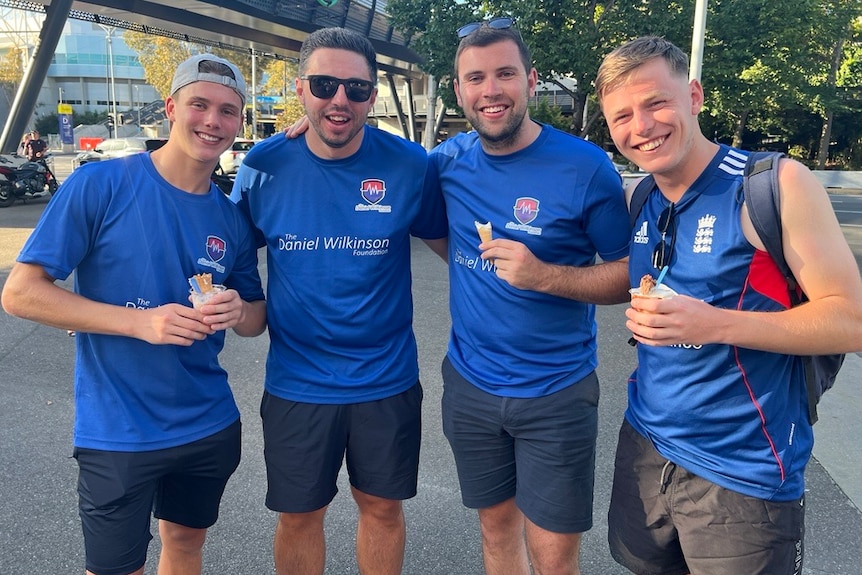 Four England fans dressed in blue at A-league soccer game.