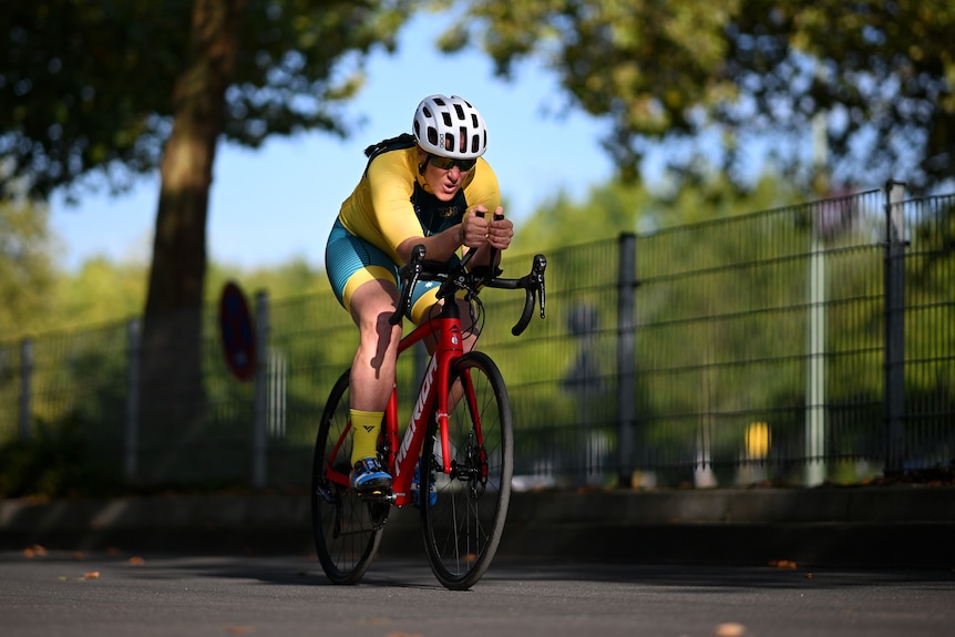 Taryn has a look of focus as she cycles past some trees.