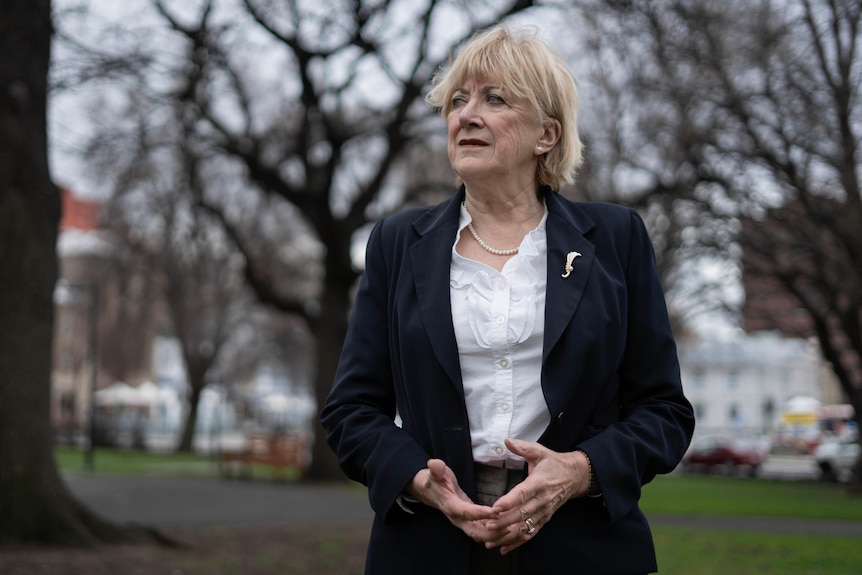 Romemary Armitage looks off camera with trees in the background. 