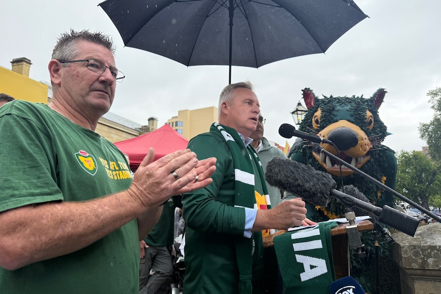 a man stands under an umbrella