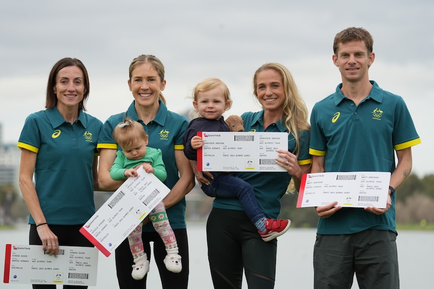 Four olympic athletes, two holding babies