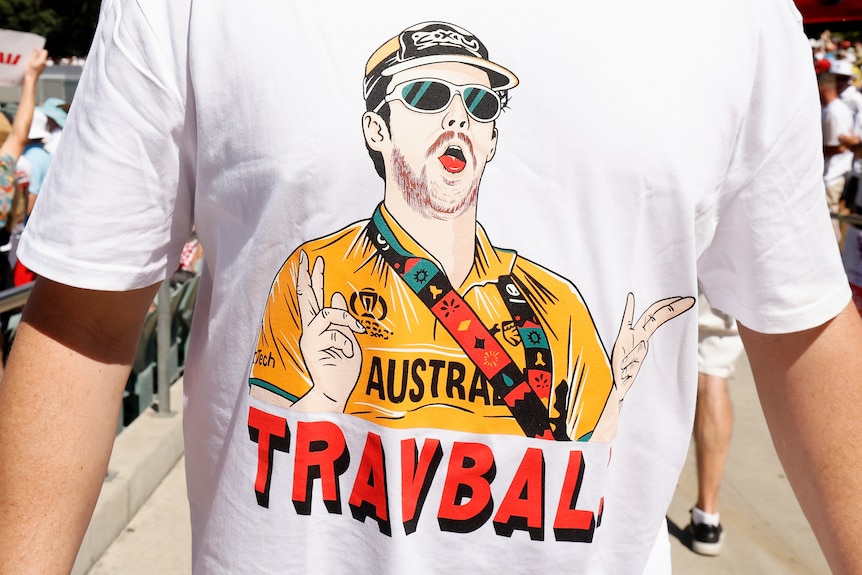 A person wearing a t-shirt with "TRAVBALL" written on it and a picture of Travis Head.