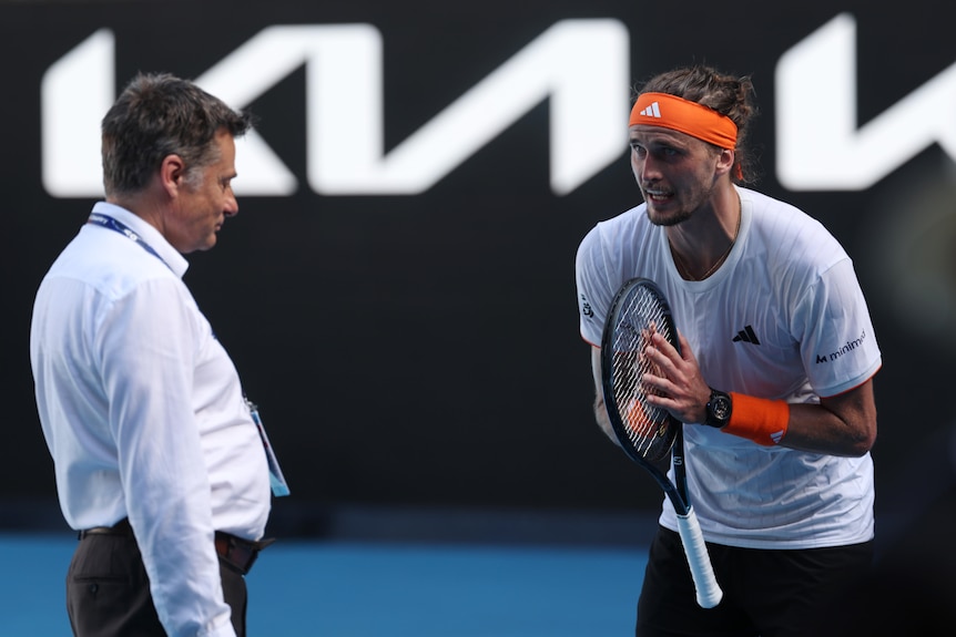 Alexander Zverev holds his tennis racquet as he pleads with the Australian Open supervisor during his semifinal.