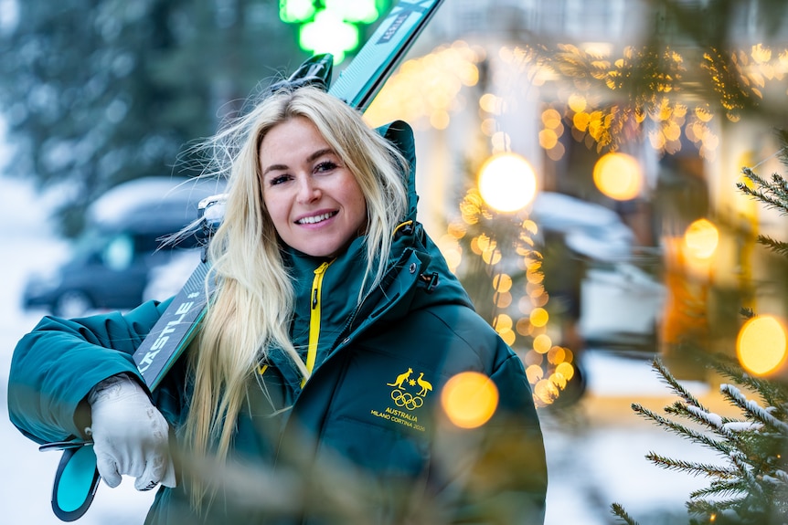 Danielle Scott stands with skis over her shoulder