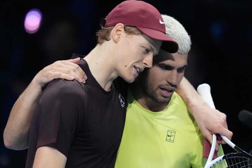 Sinner and Alcaraz embracing in a hug on court