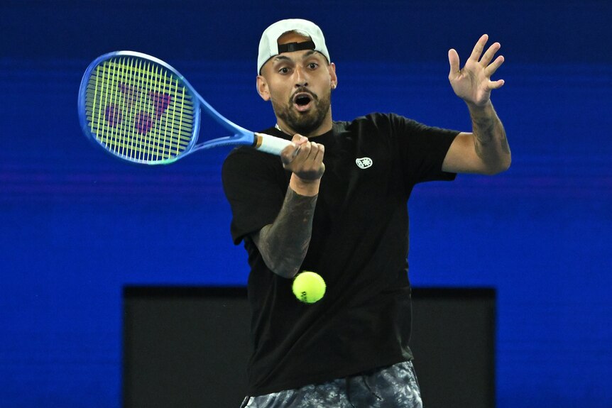 A man plays a single-handed forehand while holding his mouth open wide on a tennis court