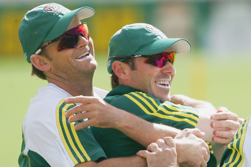 Australia cricketer Adam Gilchrist hugs teammate Damien Martyn from behind at training.