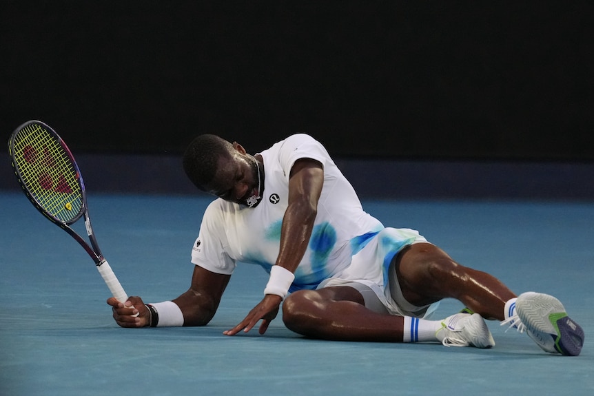 Frances Tiafoe lies on the court at the Australian Open.