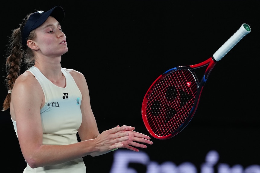 Elena Rybakina tosses her racquet while on court.