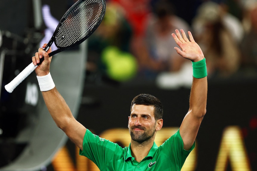 Serbia's Novak Djokovic celebrates after winning his first round match by raising his arms