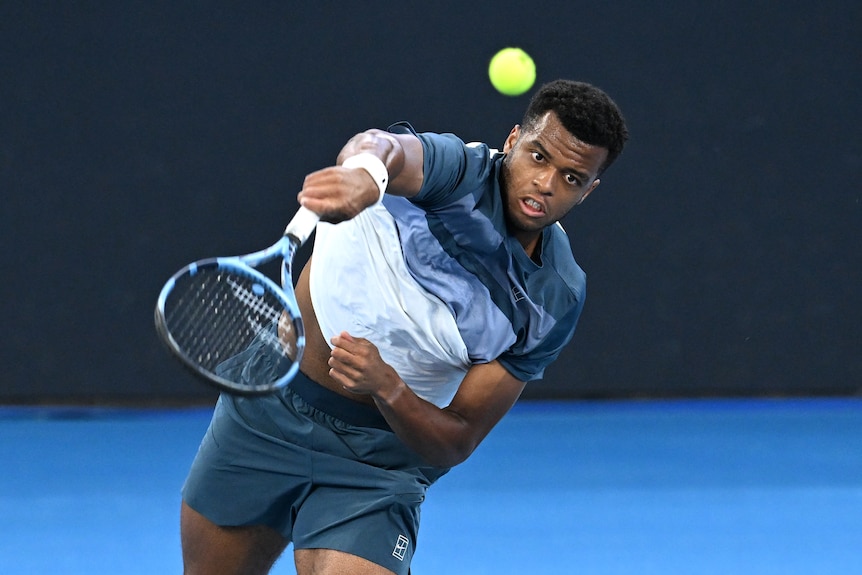A man on a tennis court serving the ball.