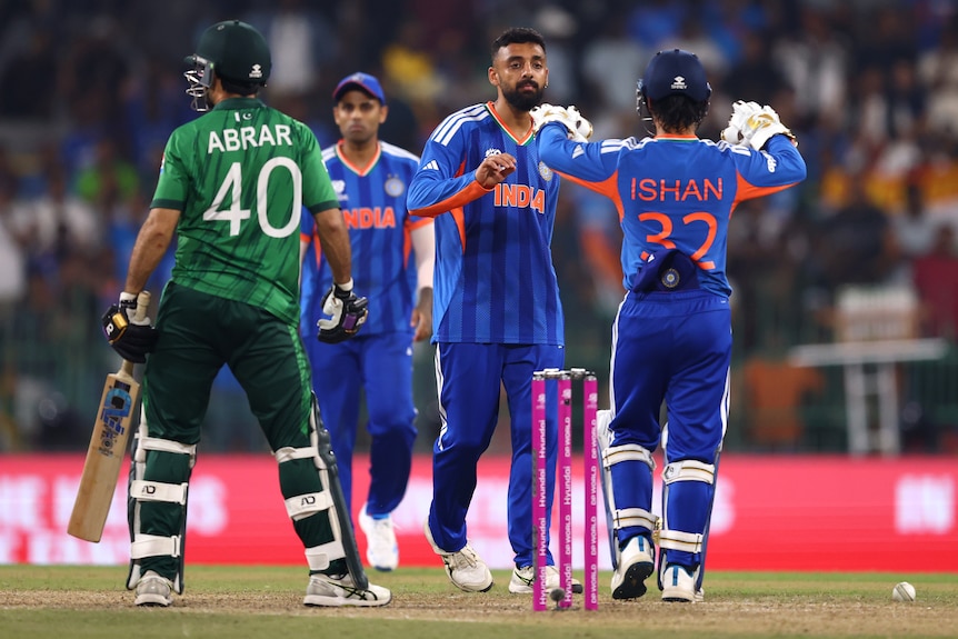 Varun Chakaravarthy high-fives teammates after taking a wicket