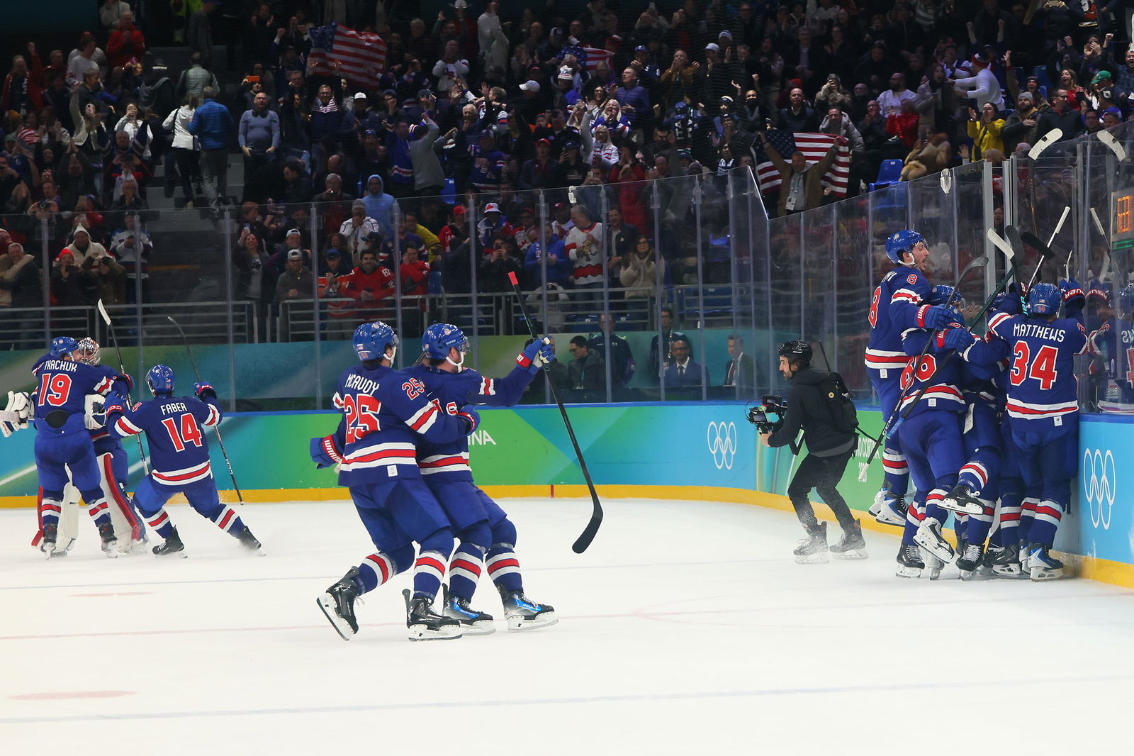 A group of ice hockey players celebrate a victory in blue and red