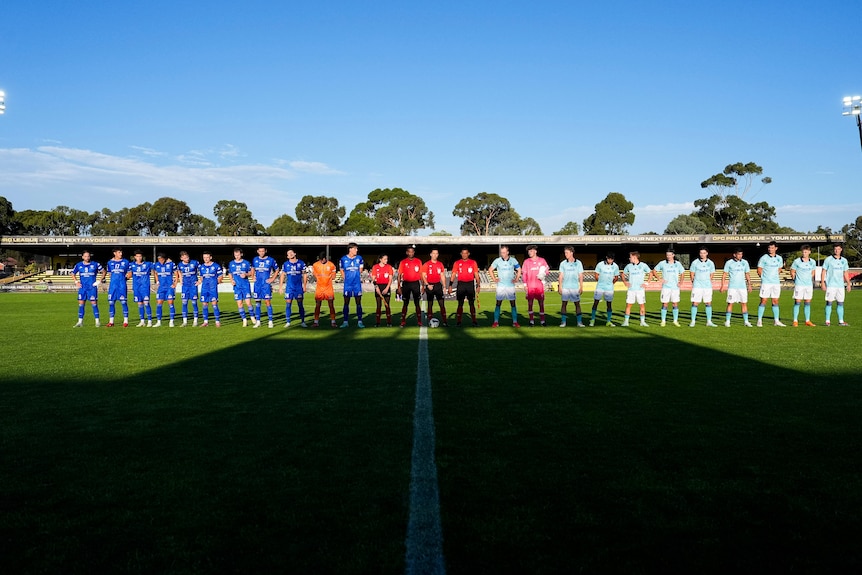 Two football teams line up against each other ahead of a match.