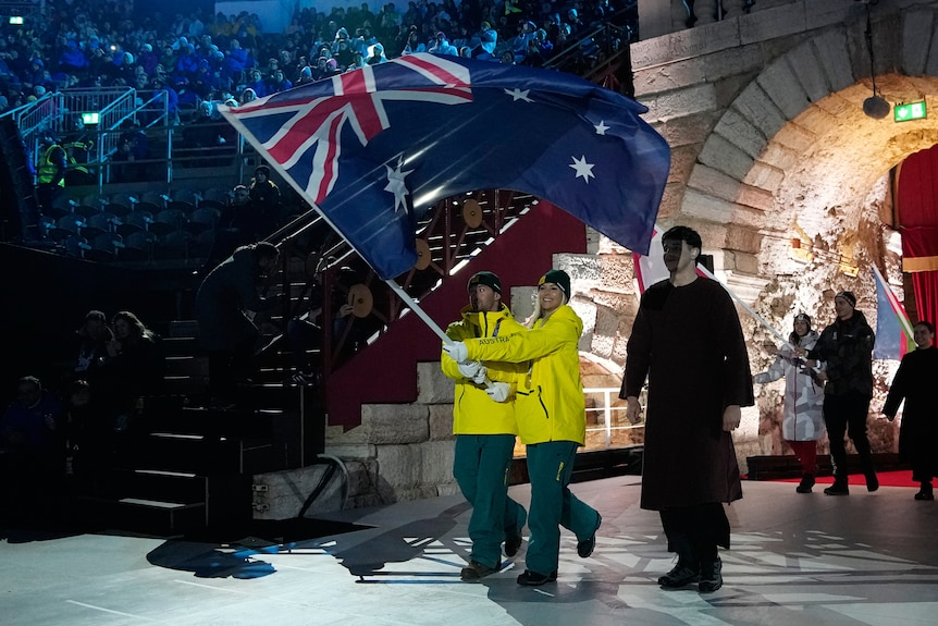 Danielle Scott and Cooper Woods carry the Australian flag