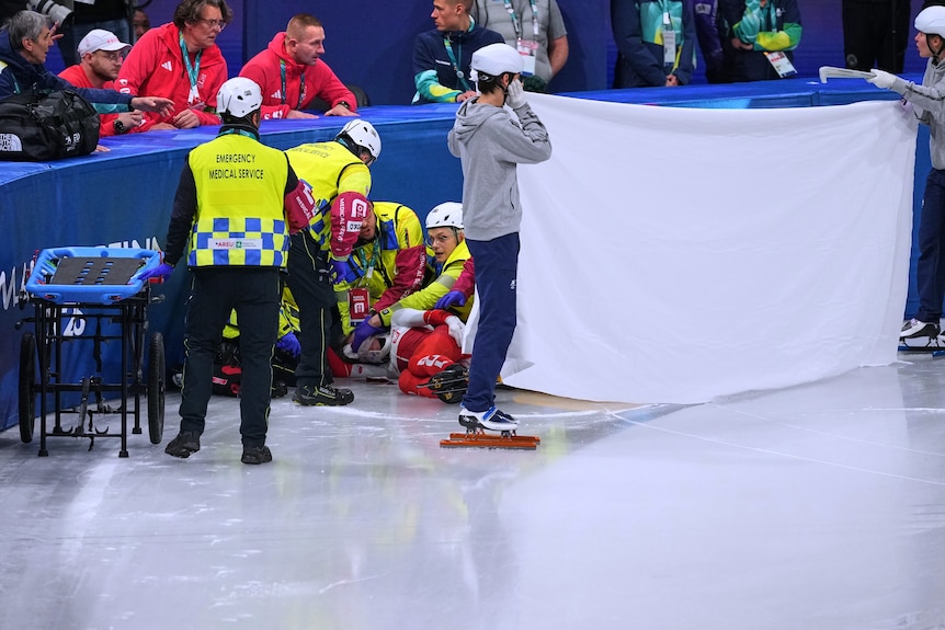 Kamila Sellier receives treatment after being cut in the face during a short track speed skating race at the Winter Olympics.