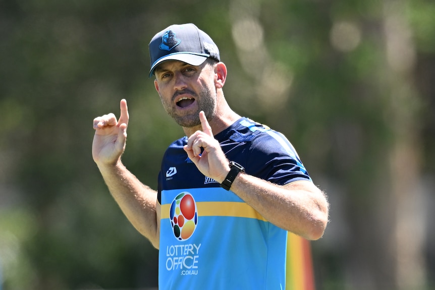 A coach demonstrates to his team during a rugby league training session 