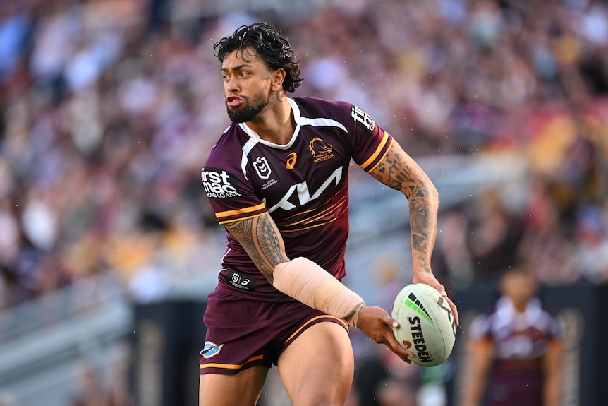 Xavier Willison running with the football, looking to his right, preparing to pass the ball