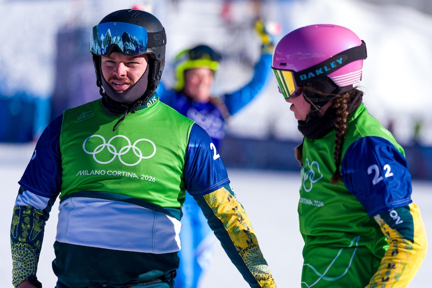 Adam Lambert and Josie Baff in Team Australia jerseys walk together.