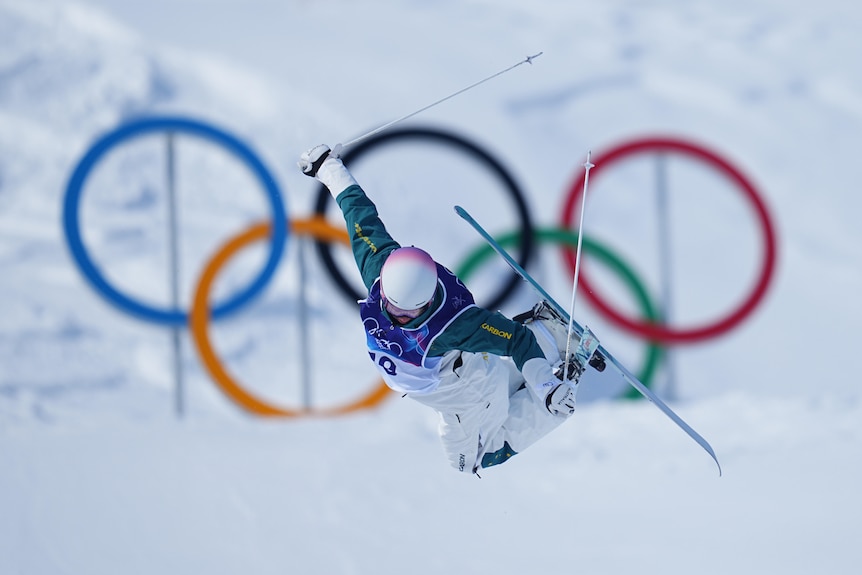 Cooper Woods leaps in front of the Olympic rings