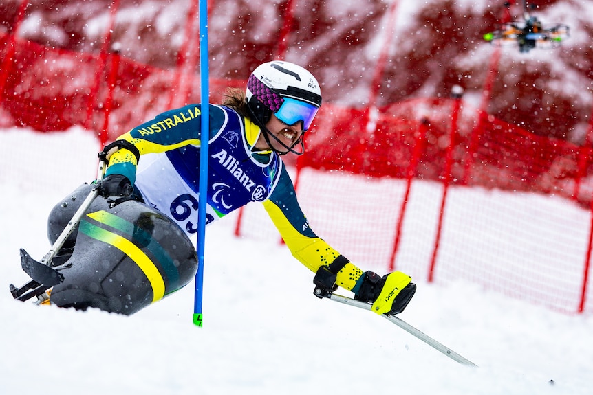 An Australia para-alpine skier manoeuvres around a gate on his sit-ski during a Winter Paralympics slalom event.