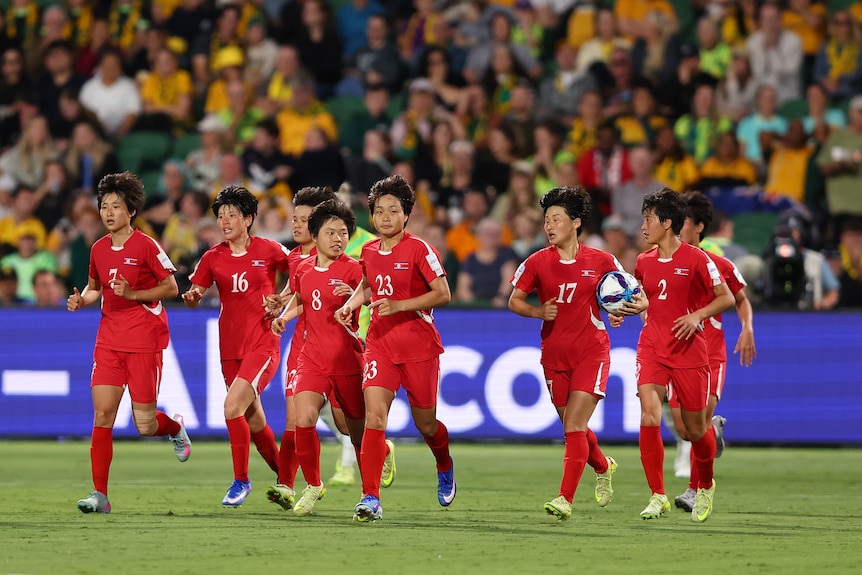 North Korea players run after scoring a goal