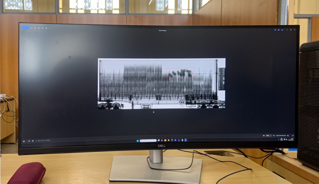 A computer monitor sowing the image of a shipping container being scanned