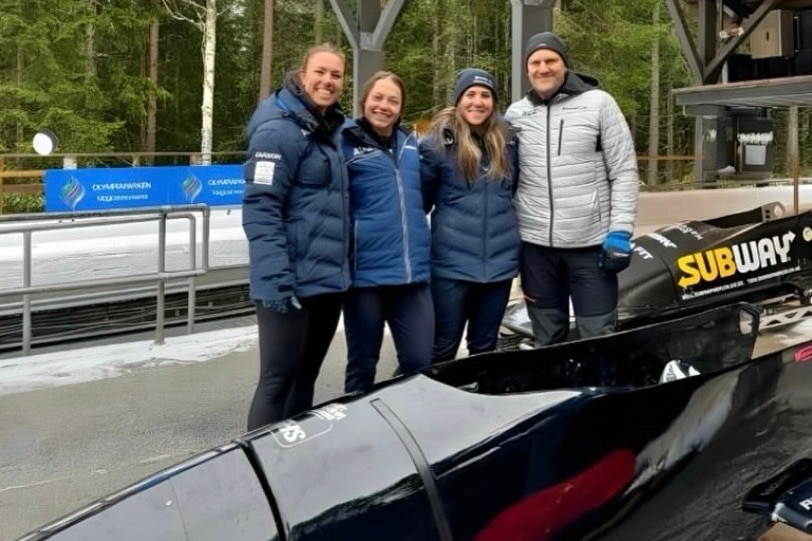 Kiara Reddingius Kristina Clonan and Bree Walker stand next to a bobsled