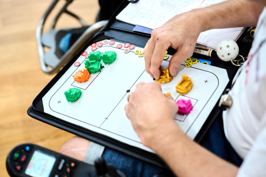 Whiteboard mockup of hockey field with mini figurines of players for strategising