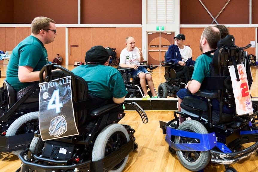 group huddle with powerchairs around coaches