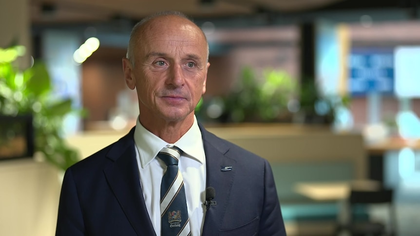 Stretch Kontelj, wearing a navy suit, standing inside a cafe.