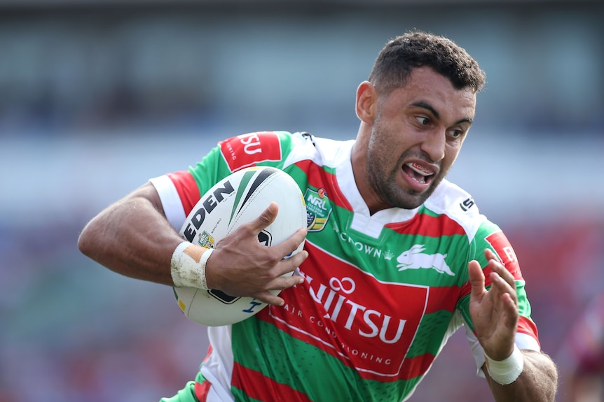 A man runs the ball during a rugby league match 