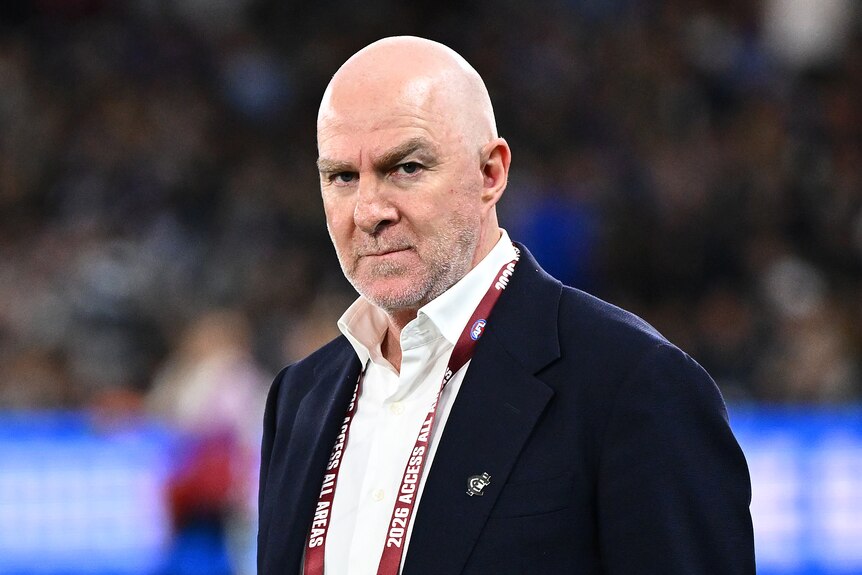 Graham Wright stands on the field wearing a suit