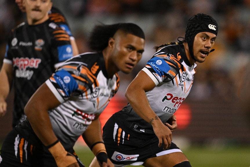 NRL players running in a warm up before a night match