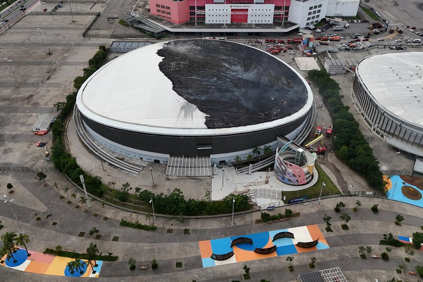 Roof of arean damaged by fire, half of roof burned.