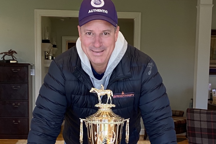 Mark Toothaker poses with a gold cup