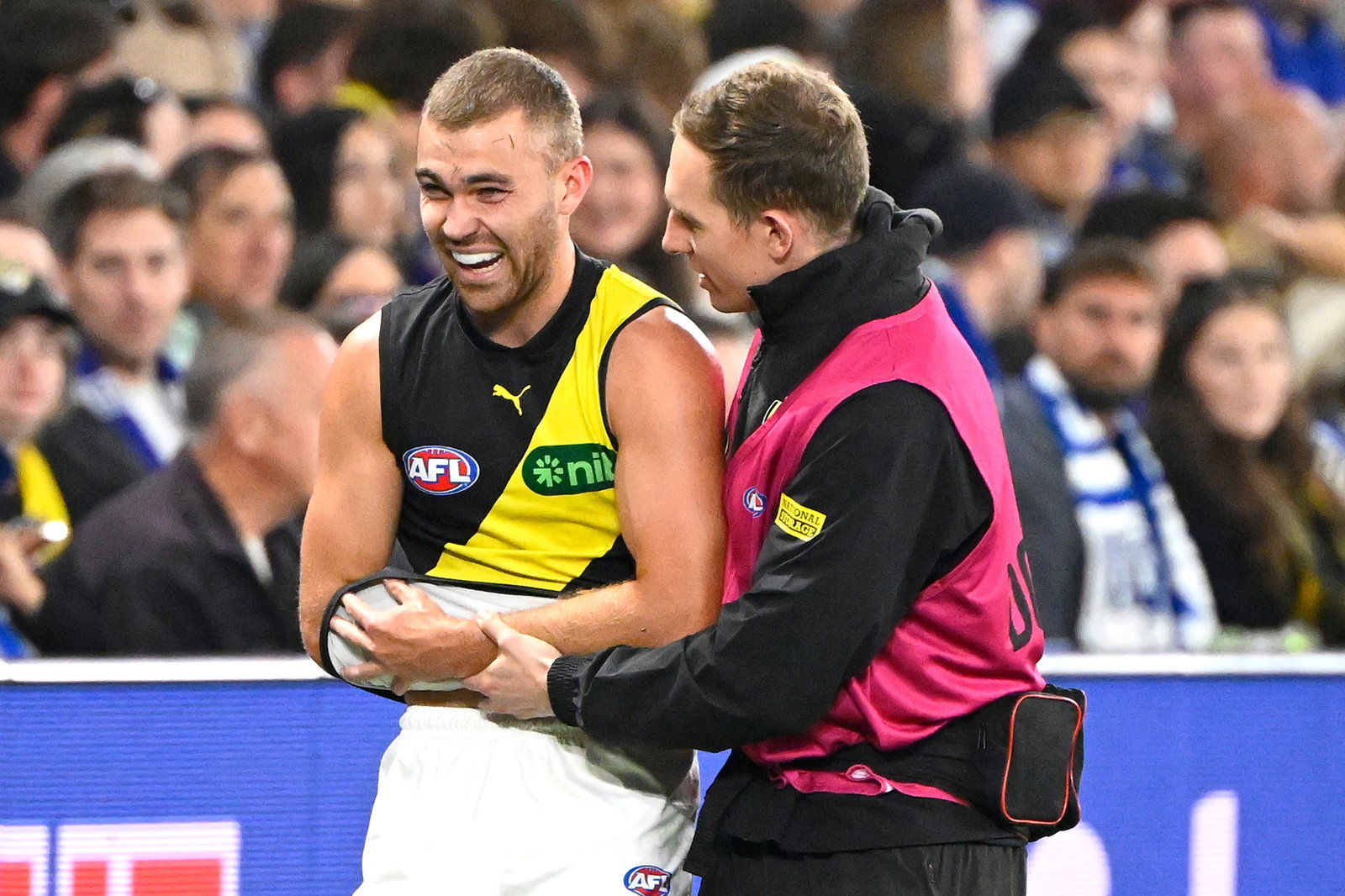 Sam Banks with his arm in a sling using his Richmond jumper.