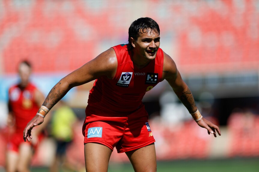 Jamarra Ugle-Hagan stands crouched with his arms wide