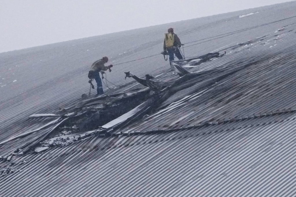 Workers examine the damage to the roof of the New Safe Confinement structure, which was built to contain the radioactive remains of Reactor No. 4 at the Chernobyl nuclear power plant, following what Ukrainian officials said was a Russian drone attack in Chernobyl, Ukraine, on February 14 last year. Photo: AP
