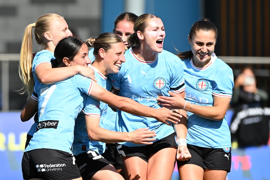 Soccer players celebrate on the pitch.