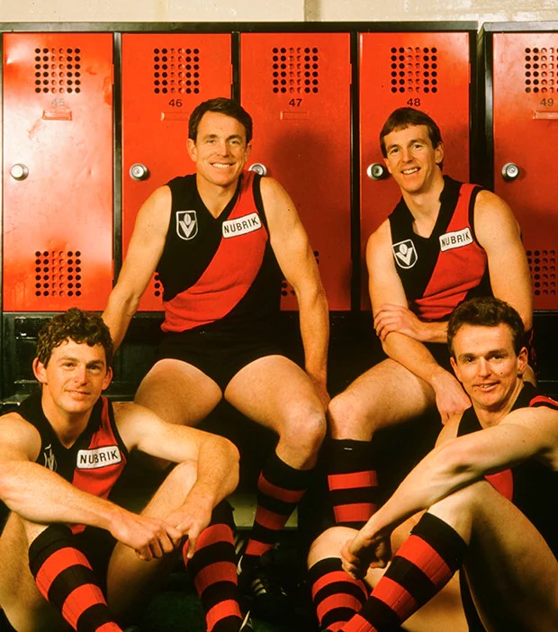 Four men in Essendon Football Club uniforms.