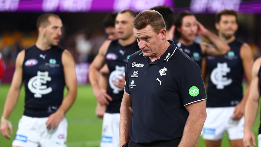 Voss walks off the ground with his head down after a loss.